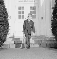 Schoolboy Leaving School Poster Print featuring a young boy stepping away from school.