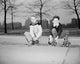 Two boys with roller skates sitting on a curb poster print