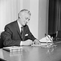Businessman Writing Behind Desk Poster Print showcasing professionalism and focus.