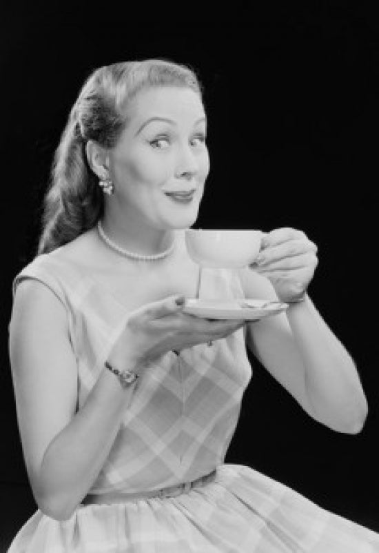Studio portrait of a young woman drinking tea, poster print.