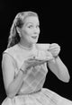 Studio portrait of a young woman drinking tea, poster print.