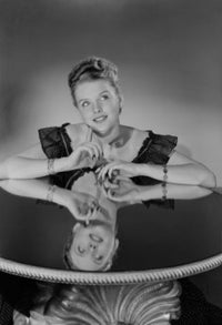 Studio shot of a young woman sitting in a chair poster print.