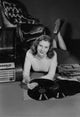 Studio portrait of a young woman with records poster print.