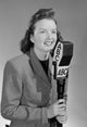 Studio portrait of a female reporter speaking into a microphone poster print.