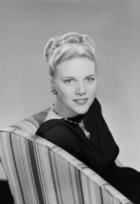 Studio portrait of young woman sitting in chair poster print.
