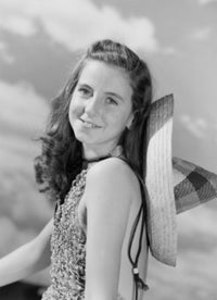 Portrait of young woman wearing sombrero against a cloudy sky.