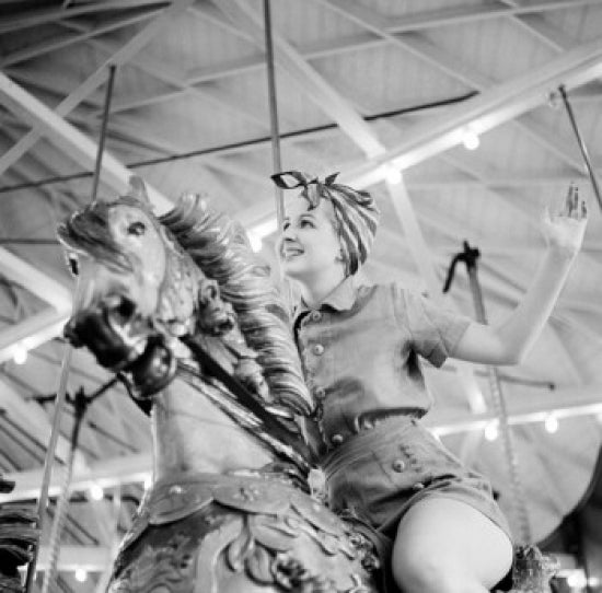 Woman Riding Merry-Go-Round Poster Print showcasing a whimsical carousel scene.