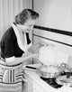 Poster print of a happy young woman making an omelet in a kitchen setting.