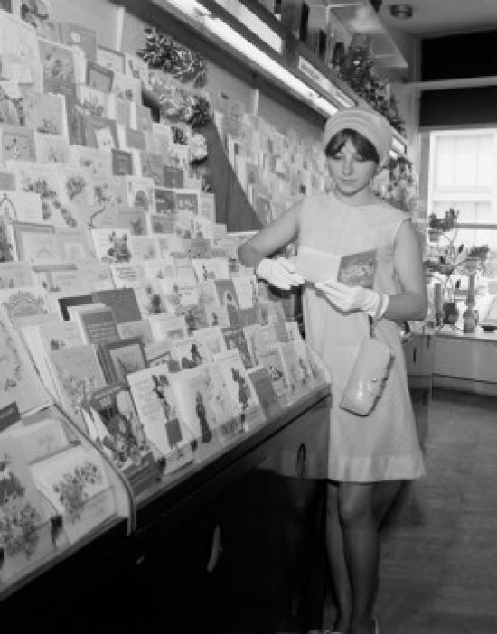 Young woman picking up postcards poster print
