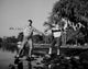 Young couple standing on pebble at lakeshore poster print
