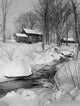 Winter scene in Peterboro, New Hampshire featuring old buildings and a brook.