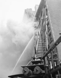 Fire engine with ladder responding to a burning building poster print.