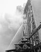 Fire engine with ladder responding to a burning building poster print.