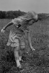 Poster print of a girl picking wildflowers, showcasing nature's beauty.