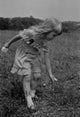 Poster print of a girl picking wildflowers, showcasing nature's beauty.