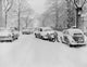 Men pushing a car down a snow-covered street poster print