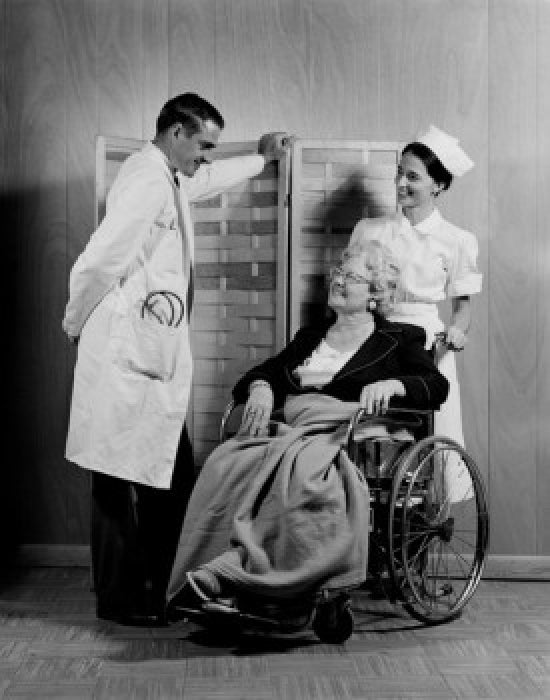 Doctor chatting with senior patient in wheelchair poster print.