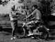 Teenage boy on motorbike talking to a teenage girl poster print.