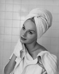 Close-up poster print of a young woman drying her neck with a towel.
