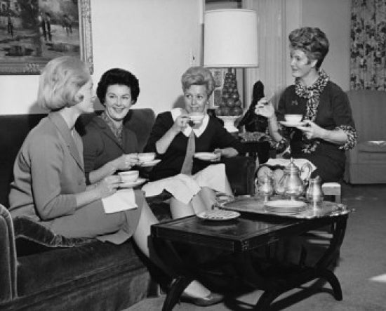 Four young women sitting together drinking tea poster print