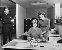 Poster print of two businesswomen reading a file and a businessman at an office door.