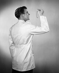 Rear view of a male scientist examining a test tube poster print