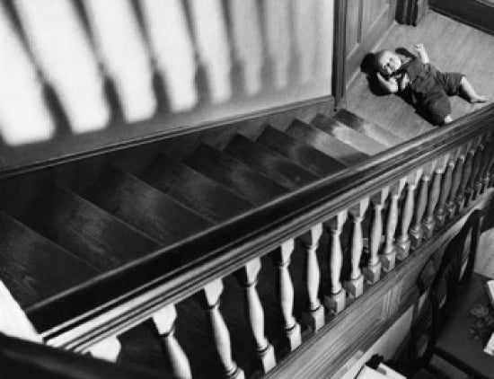 High angle view of a baby lying near a staircase poster print.