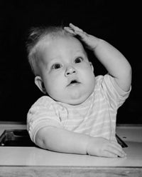 Charming baby sitting in a high chair poster print