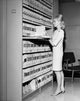 Businesswoman organizing files in a filing cabinet poster print.