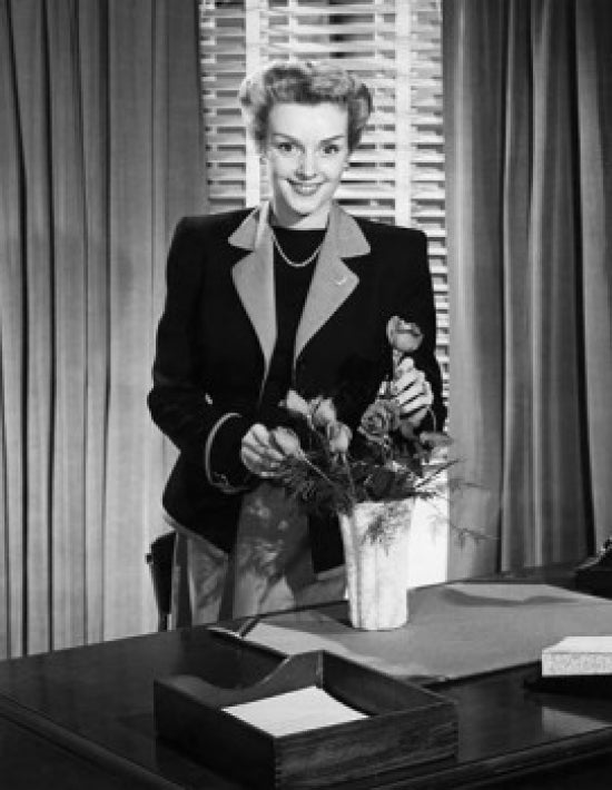 Poster print of a businesswoman arranging flowers, smiling.