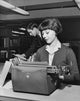 Young woman typing a document on a typewriter in an office setting