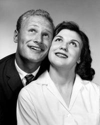 Studio portrait of a mid-adult couple looking up, poster print.