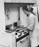 Young woman working in a kitchen poster print.