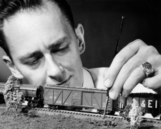 Man Making Scaled Down Model of Railroad Poster Print showcasing a dedicated model builder.