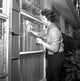 Woman cleaning window poster print on heavy stock paper.