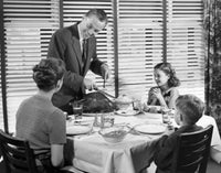 Father carving a turkey at the dinner table poster print.