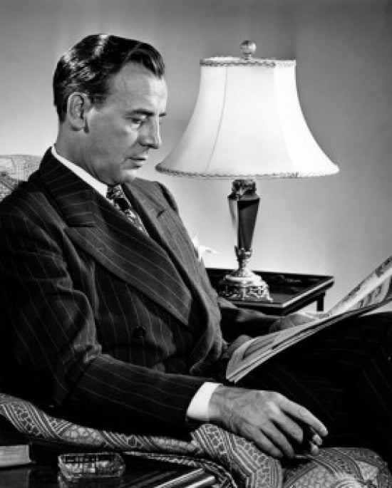 Man Sitting in Armchair Reading Newspaper Poster Print
