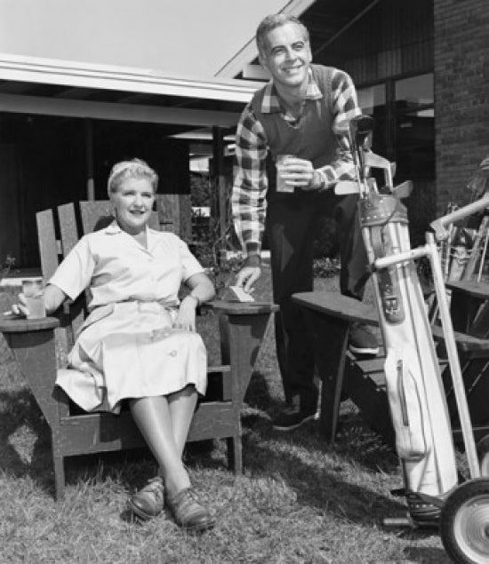Mid adult couple holding drinks and golf clubs poster print.