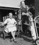 Mid adult couple holding drinks and golf clubs poster print.