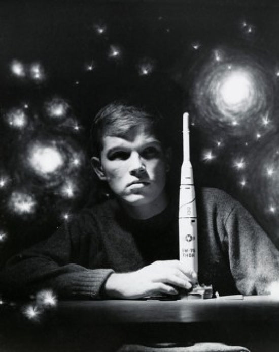 Close-up poster of a teenage boy holding a model rocket.
