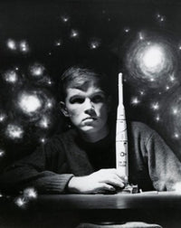 Close-up poster of a teenage boy holding a model rocket.