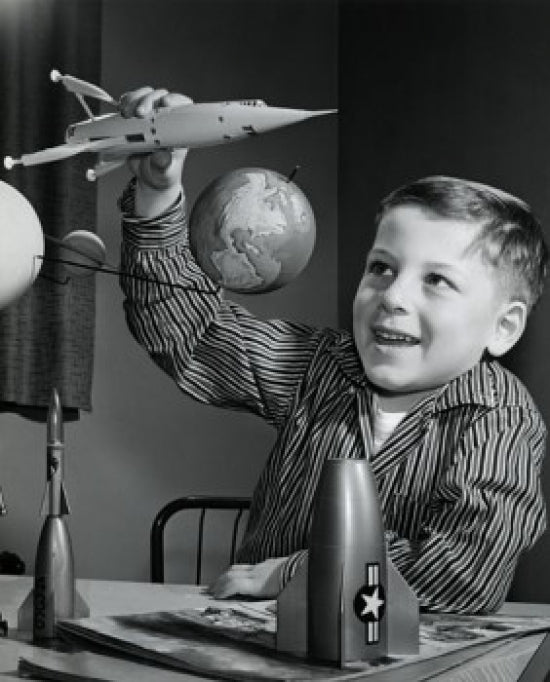 Close-up poster of a boy playing with a model rocket.