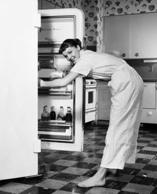 Poster Print of a young woman standing in front of a refrigerator