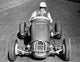 Mid adult man driving a race car on a motor racing track poster print.