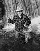 Mid adult man smiling holding a fish in fishing net