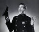 Portrait of a police officer holding a uniform cap and laughing.