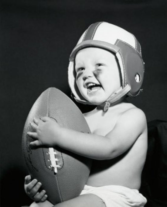 Close-up of a baby boy holding a football, charming poster print.