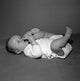 Adorable baby girl lying on back sucking toes poster print.