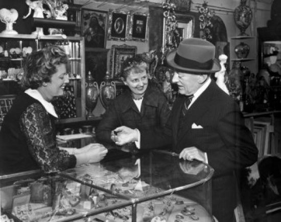 Poster print featuring a senior man and two mature women in an antique shop.