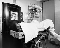 Female radiologist taking an x-ray of a patient poster print.